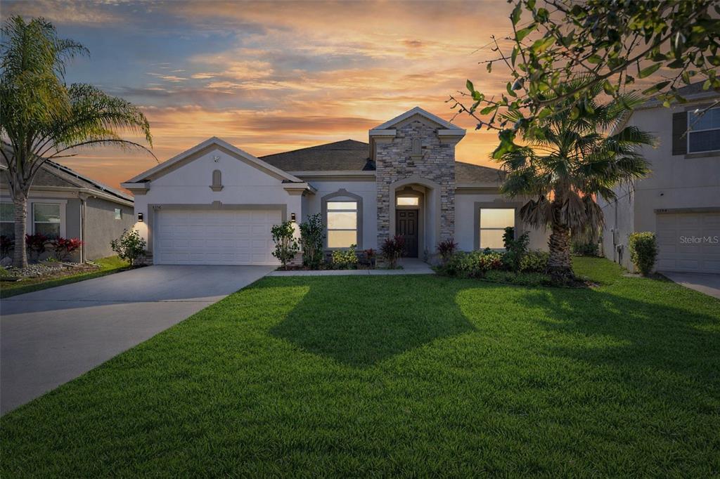 a front view of a house with a garden and plants