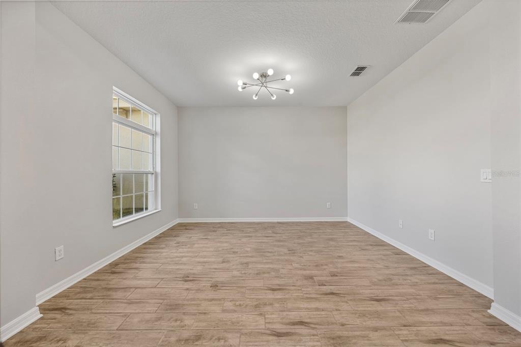 5356 Ragusa Loop St. Cloud, FL 34771 - Photo 16 of 69 wooden floor in an empty room with a window