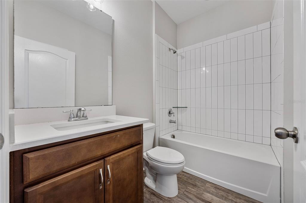 5356 Ragusa Loop St. Cloud, FL 34771 - Photo 20 of 69 a bathroom with a sink a toilet and shower