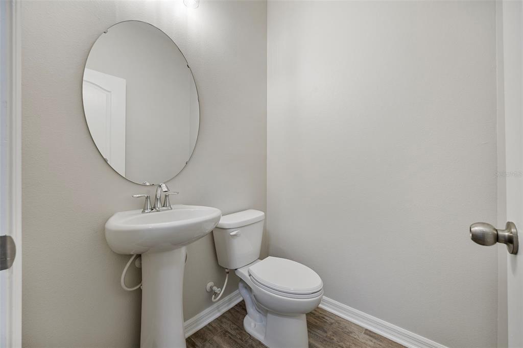 5356 Ragusa Loop St. Cloud, FL 34771 - Photo 23 of 69 a bathroom with a toilet a sink and mirror