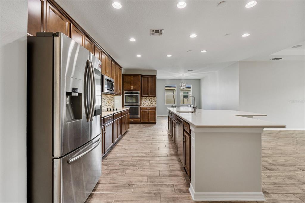 5356 Ragusa Loop St. Cloud, FL 34771 - Photo 25 of 69 a kitchen with stainless steel appliances granite countertop a refrigerator and a sink