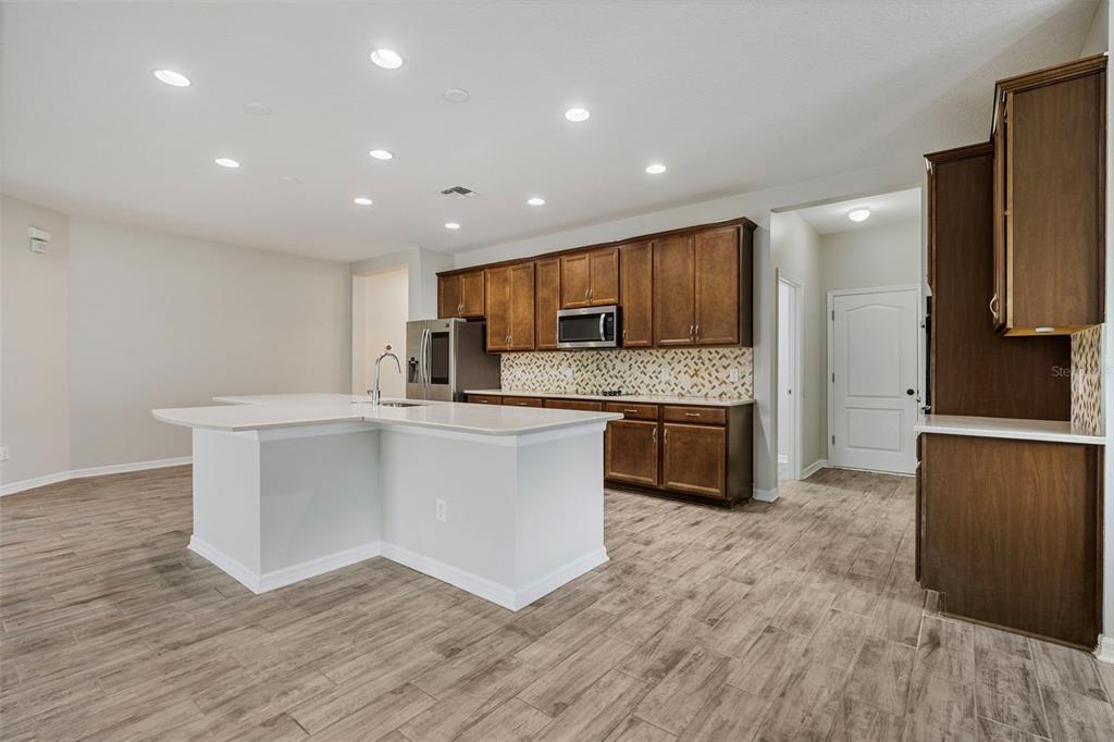 5356 Ragusa Loop St. Cloud, FL 34771 - Photo 27 of 69 a kitchen with a refrigerator and a stove top oven
