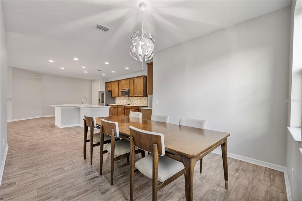 5356 Ragusa Loop St. Cloud, FL 34771 - Photo 29 of 69 a view of a dining room with furniture and wooden floor