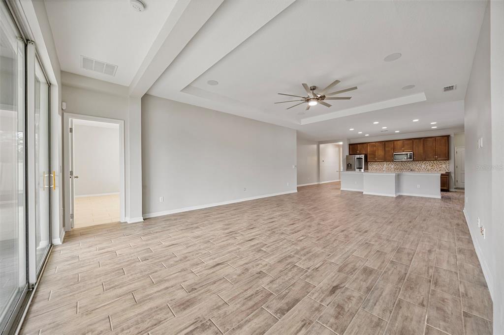 5356 Ragusa Loop St. Cloud, FL 34771 - Photo 36 of 69 wooden floor in an empty room with a ceiling fan