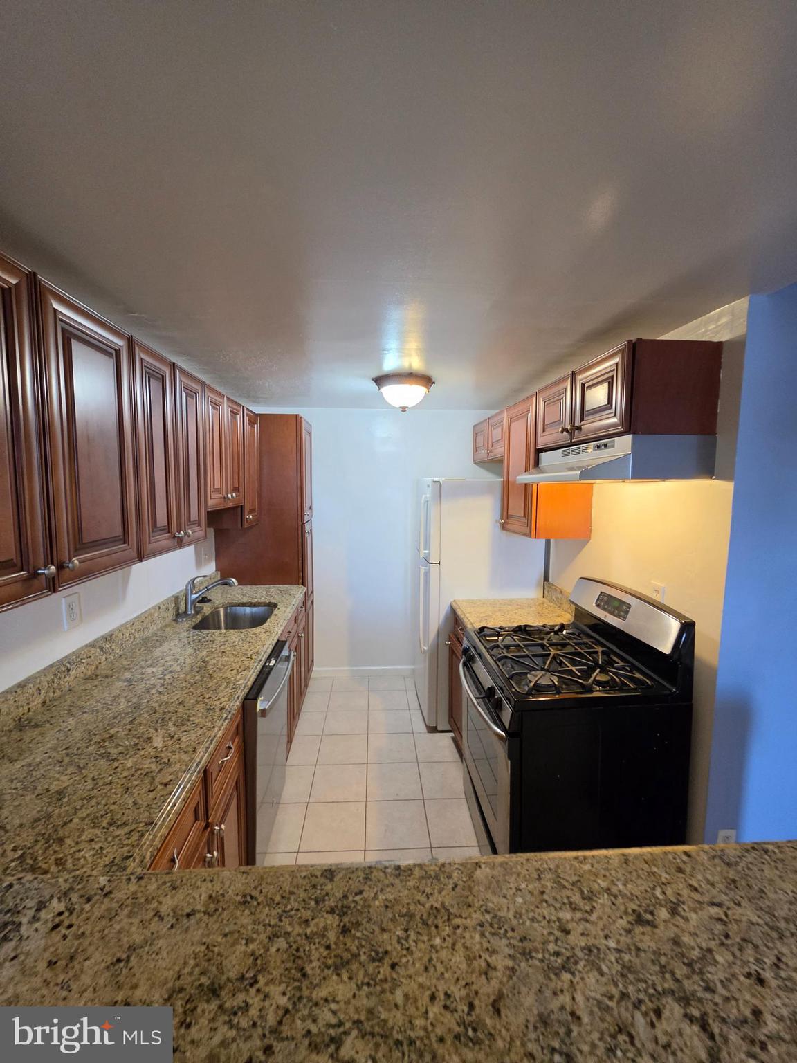 4600 Duke Street, Unit 507 Alexandria, VA 22304 - Photo 7 of 16 a kitchen with stainless steel appliances granite countertop a stove a sink and a refrigerator