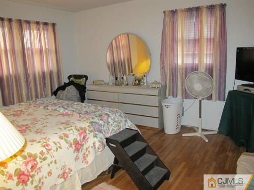 770 Magnolia Road North Brunswick, NJ 08902 - Photo 18 of 25 a bedroom with a bed a dresser and flat screen tv
