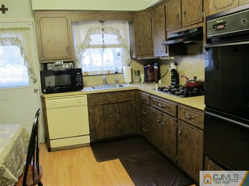 770 Magnolia Road North Brunswick, NJ 08902 - Photo 8 of 25 a kitchen with a sink a stove and cabinets