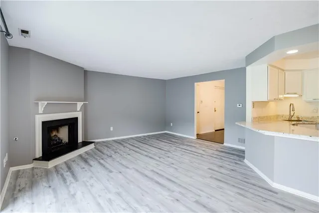 a view of empty room with wooden floor and a fireplace