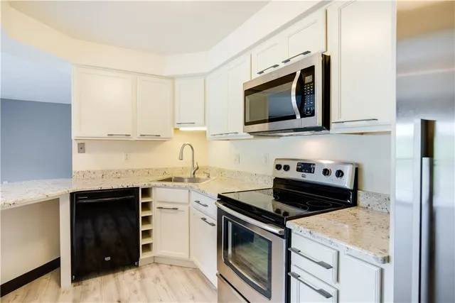 a kitchen with stainless steel appliances a stove microwave and sink