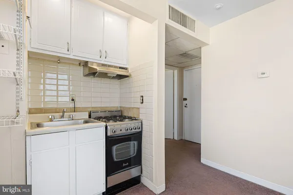 a kitchen with a stove sink and cabinets