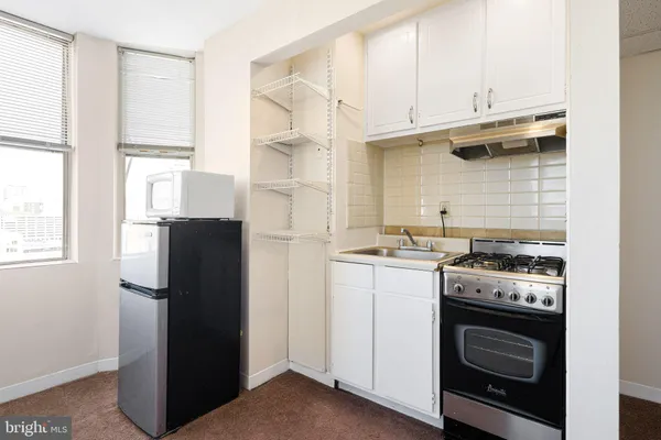 a kitchen with a stove top oven and refrigerator