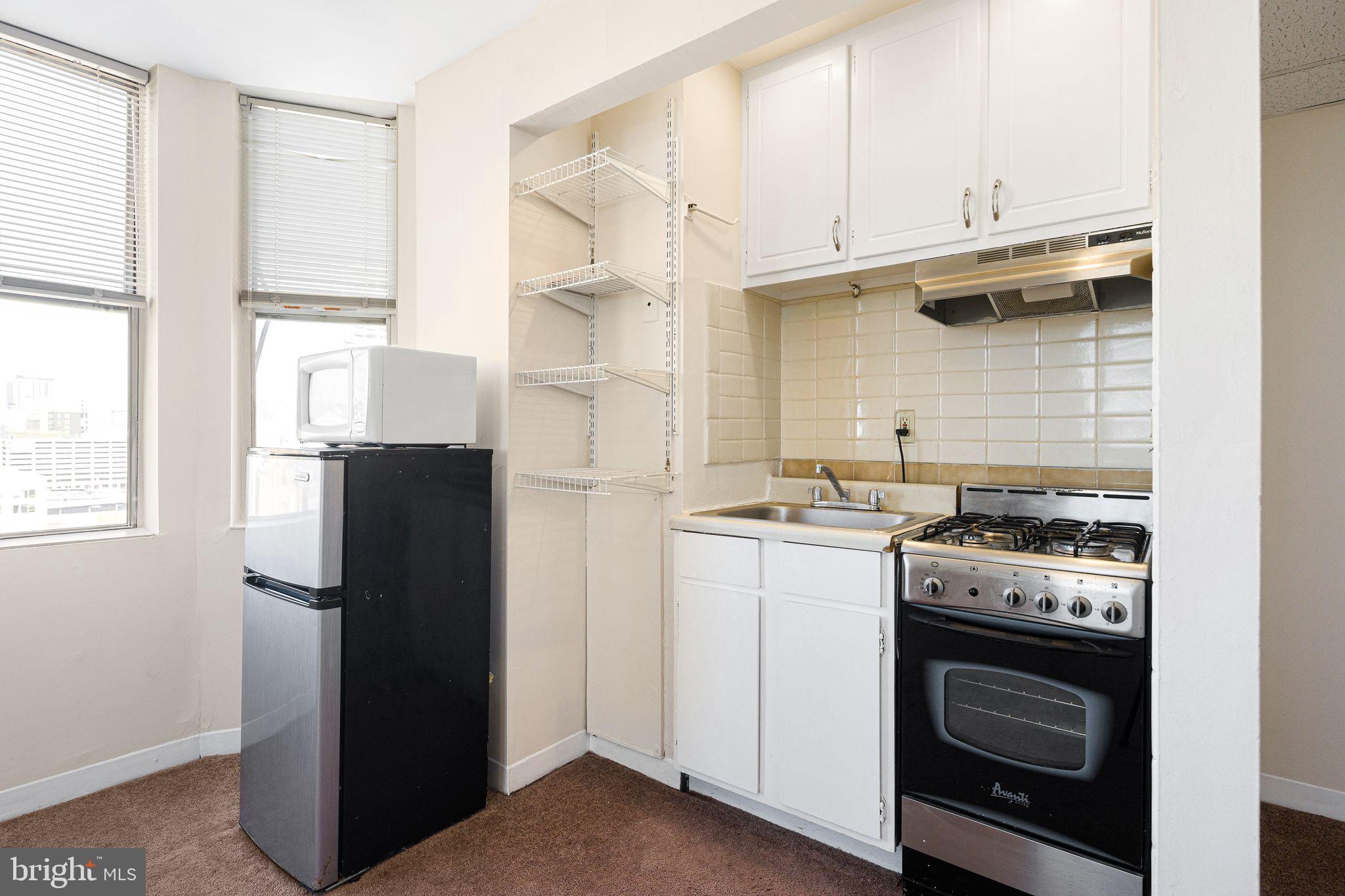 2135 Walnut Street, Unit 1103 Philadelphia, PA 19103 - Photo 8 of 18 a kitchen with a stove top oven and refrigerator