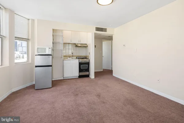 a view of a kitchen with a sink a refrigerator and window