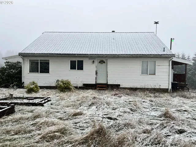 a backyard of a house with large trees and wooden fence