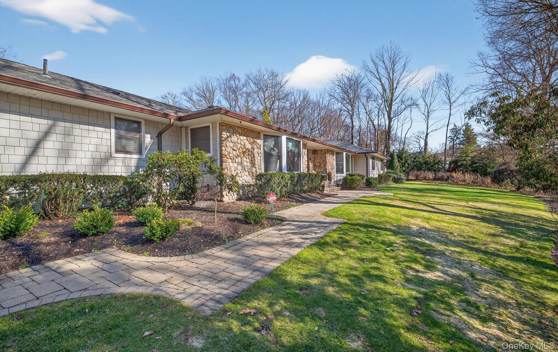 a front view of a house with garden and trees
