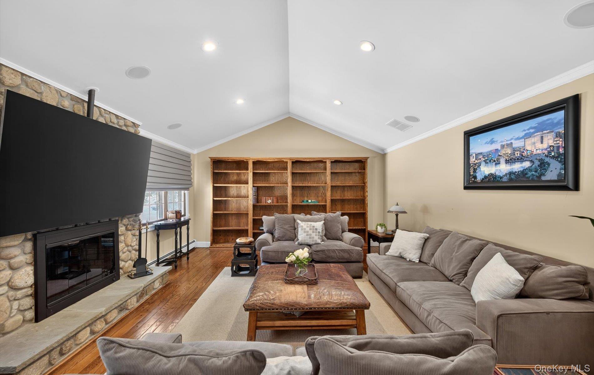 15 Tiber Road Syosset, NY 11791 - Photo 14 of 46 a living room with furniture a flat screen tv and a fireplace