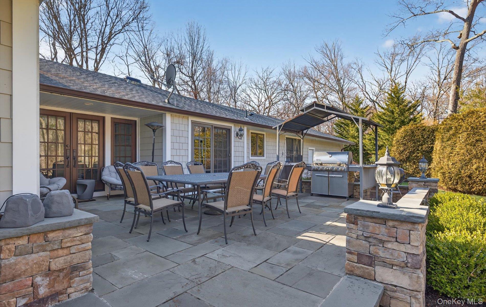 15 Tiber Road Syosset, NY 11791 - Photo 42 of 46 a view of a patio with table and chairs and floor to ceiling window