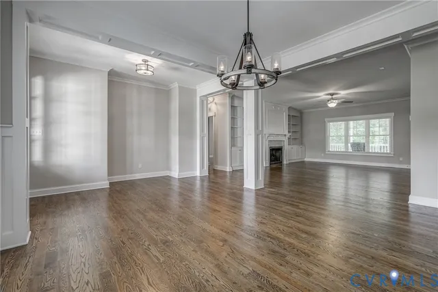 a view of a room with wooden floor a ceiling fan and windows