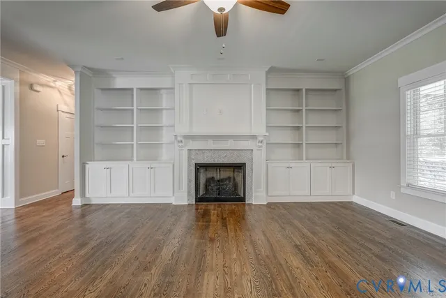wooden floor fireplace and windows in an empty room