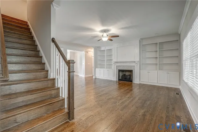 a view of a livingroom with wooden floor and a fireplace
