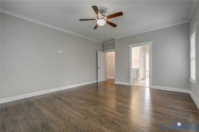a view of an empty room with window and wooden floor