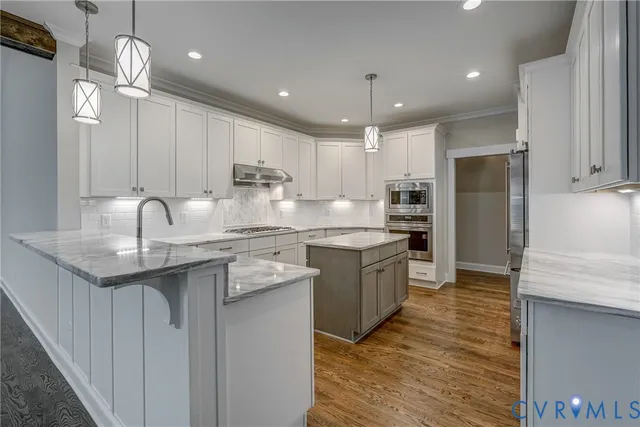 a kitchen with kitchen island granite countertop a sink stainless steel appliances and white cabinets