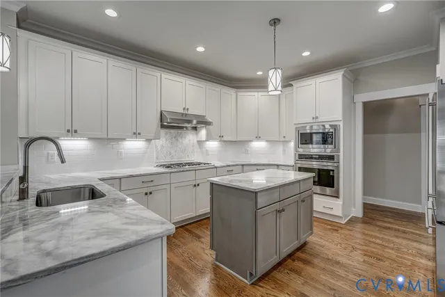 a kitchen with stainless steel appliances granite countertop a sink stove and refrigerator
