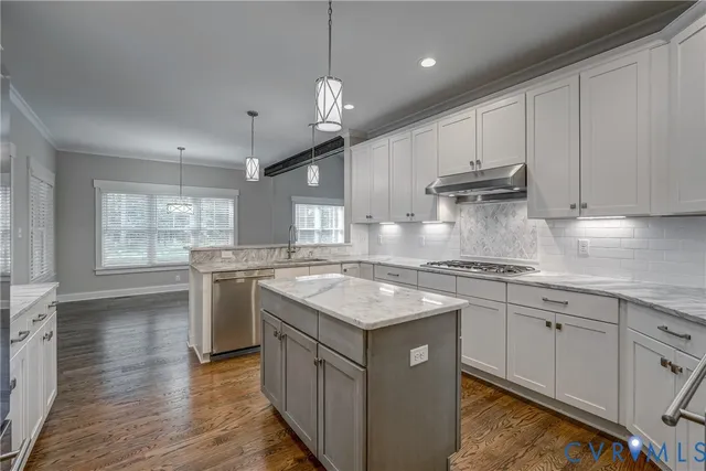 a kitchen with granite countertop a sink a counter space appliances and cabinets