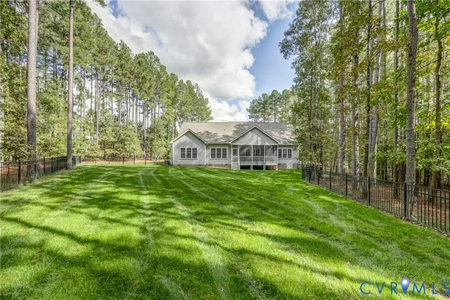 a view of a house with a big yard and large trees