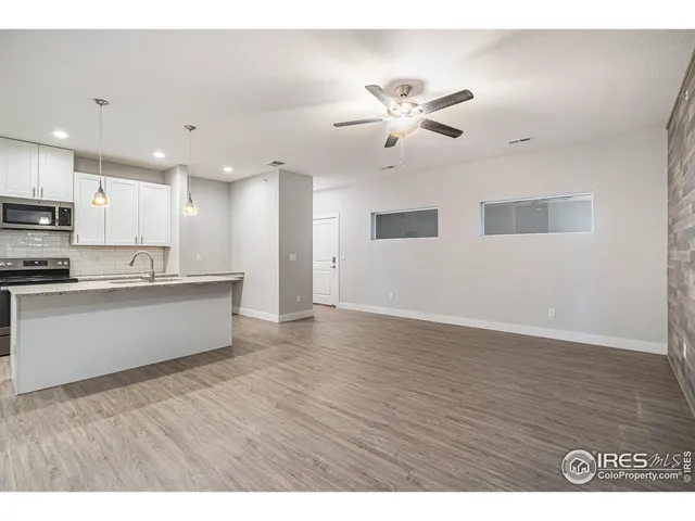 a view of kitchen with refrigerator cabinet and wooden floor