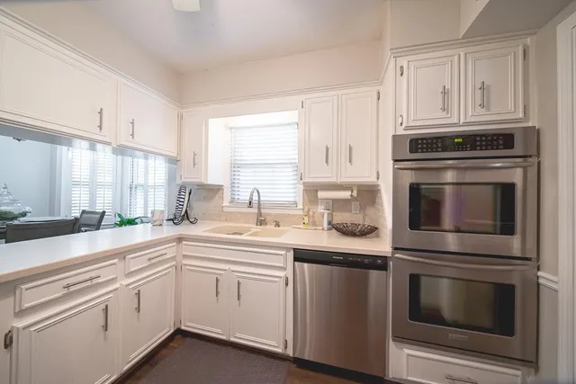 a kitchen with cabinets stainless steel appliances and sink