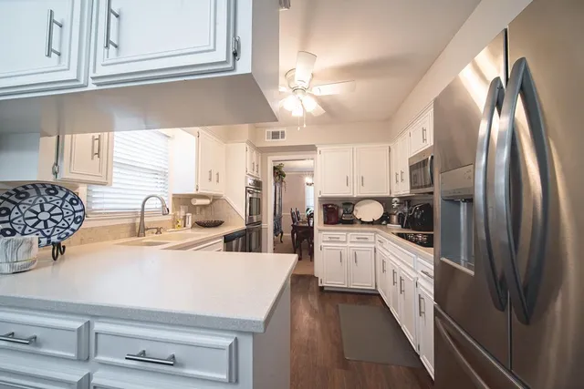 a kitchen with kitchen island granite countertop a sink appliances cabinets and a counter top space