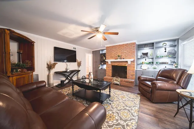 a living room with furniture a fireplace and a flat screen tv
