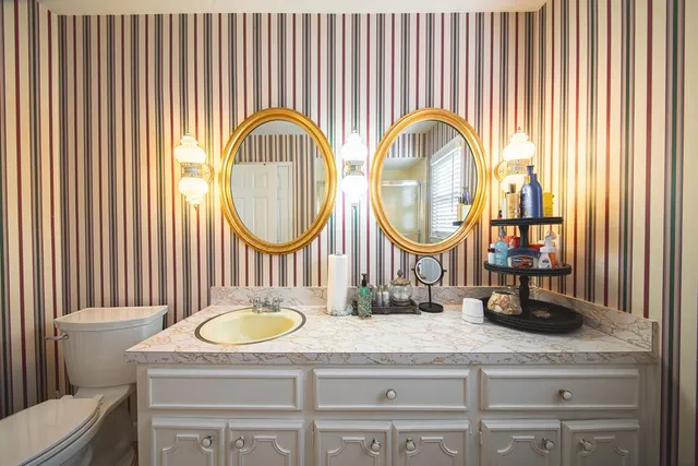 a bathroom with a granite countertop a sink and a mirror