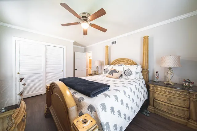 a bedroom with a bed and a lamp on the dresser