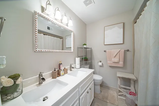 a bathroom with a sink vanity mirror and toilet