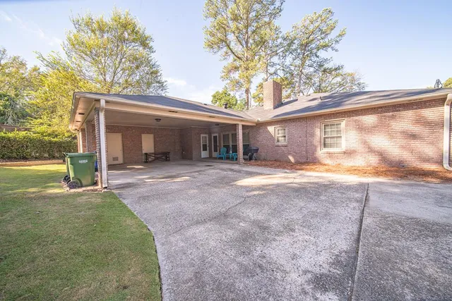 a view of a house with backyard and a tree