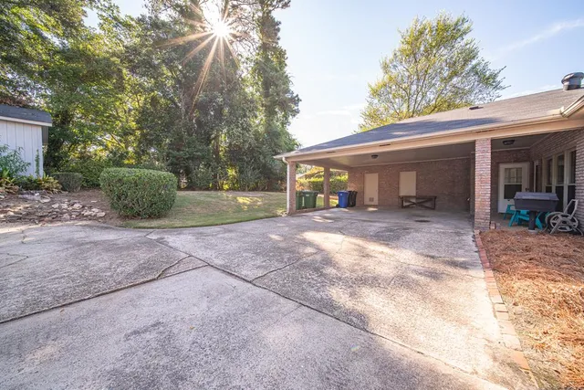 a view of a house with backyard and trees