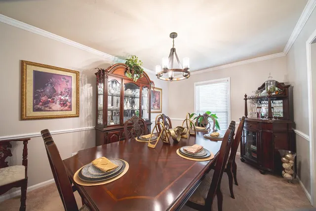 a view of a dining room with furniture a chandelier and wooden floor