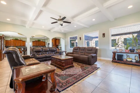 a large living room with stainless steel appliances kitchen island granite countertop a large counter top and cabinets