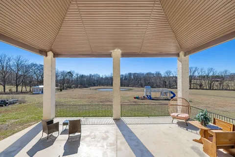 a view of a house with a big yard and large trees