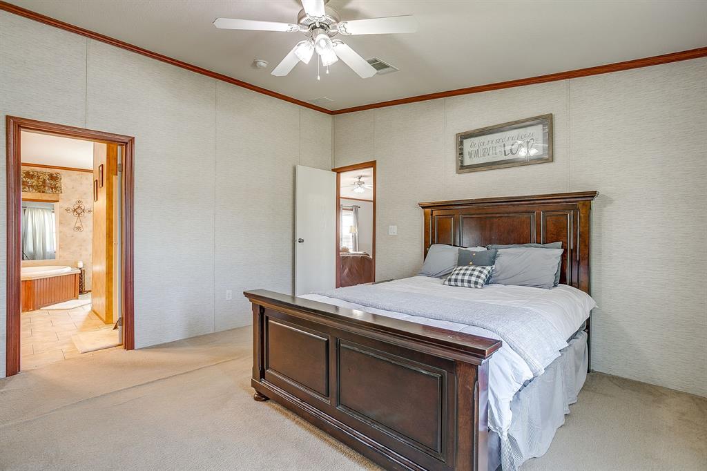 321 Young Road Millsap, TX 76066 - Photo 16 of 28 a bedroom with a bed and a chandelier