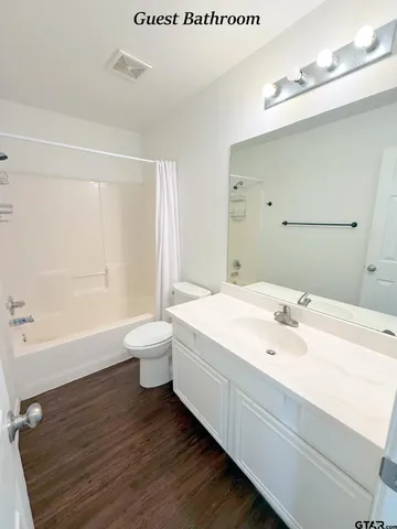 a spacious bathroom with a granite countertop sink a toilet and a bathtub