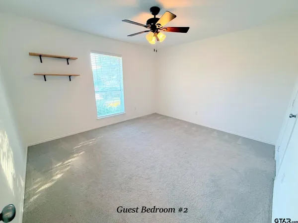 a view of a room with a window and a ceiling fan