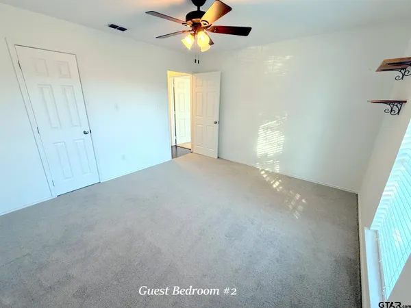 a view of a livingroom with a ceiling fan and window