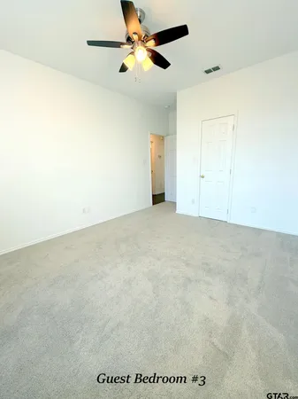 an empty room with a ceiling fan and a window