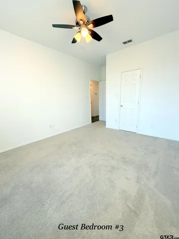 an empty room with a ceiling fan and a window