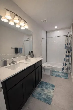 a bathroom with a double vanity sink mirror double and shower