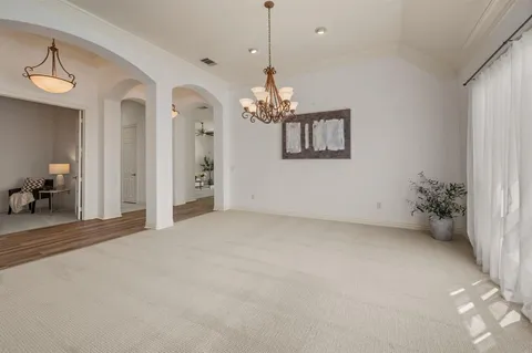 a view of a livingroom with a chandelier fan and windows