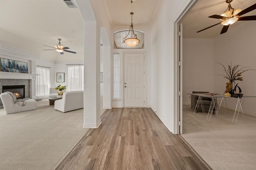 10605 Murray S Johnson Street Denton, TX 76207 - Photo 14 of 38 Entryway featuring ceiling fan, light colored carpet, arched walkways, and light wood-type flooring